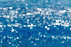 Blurry blue sea with light reflections